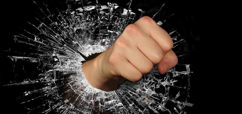 A fist breaking through glass.