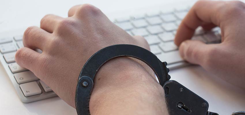 Man typing while handcuffed