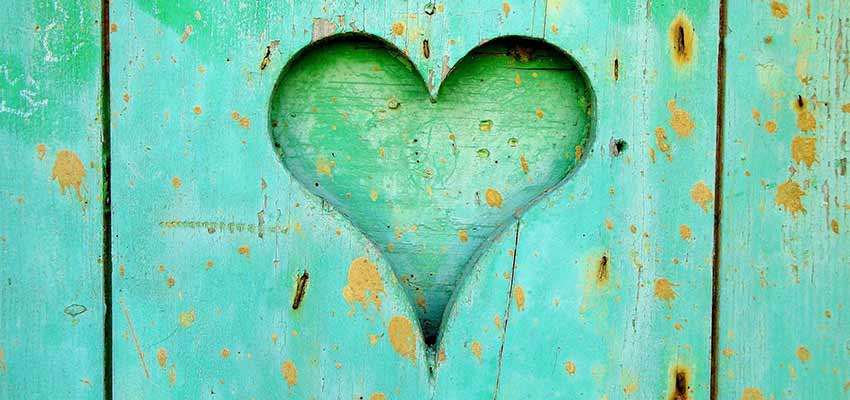A heart carved into a wooden fence.