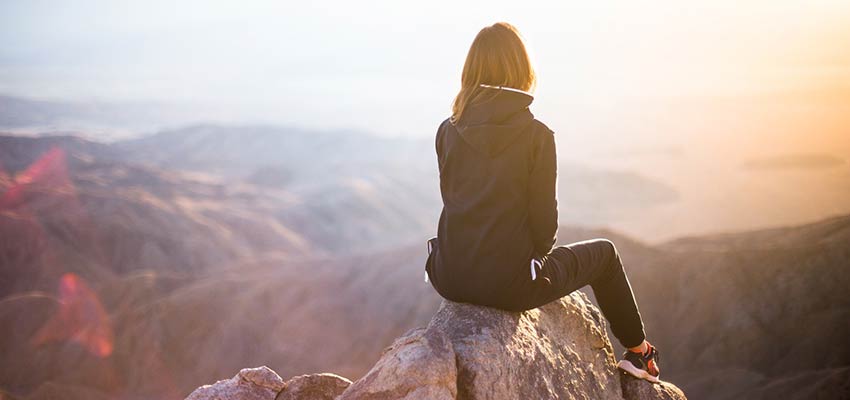 Woman sitting on a rock.