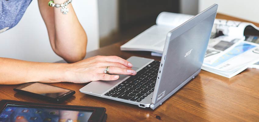 Woman typing on a laptop.