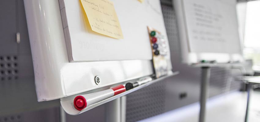 A whiteboard with post-it notes attached.