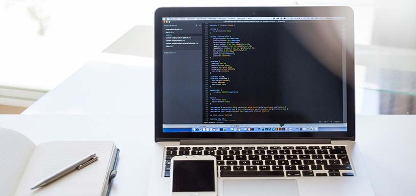 A laptop computer with CSS code displayed.