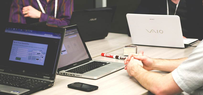 People gathered at a desk for a meeting.