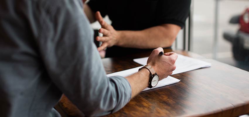 People having a discussion at a desk.
