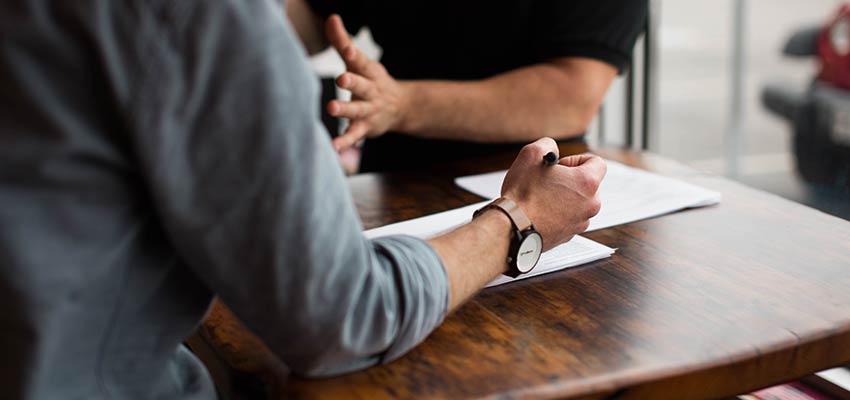 Men sitting at a table and having a discussion.
