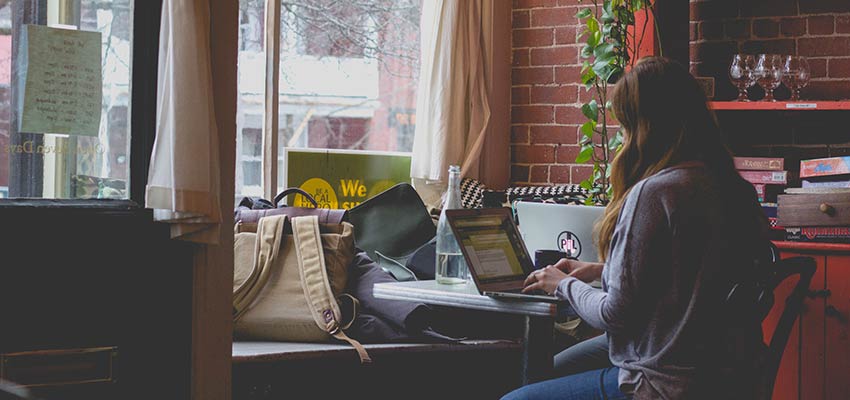 A woman works at a laptop computer.