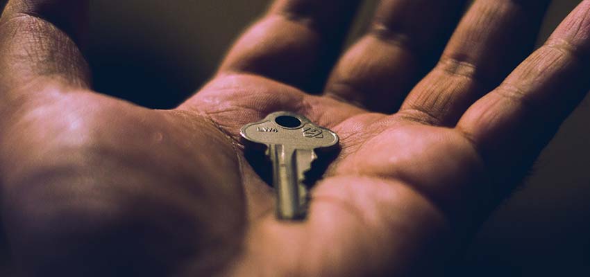 Man holding a key in hand.