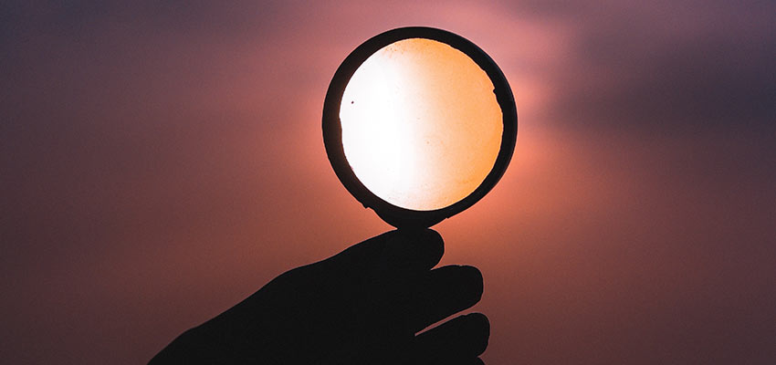 A person holding a magnifying glass.
