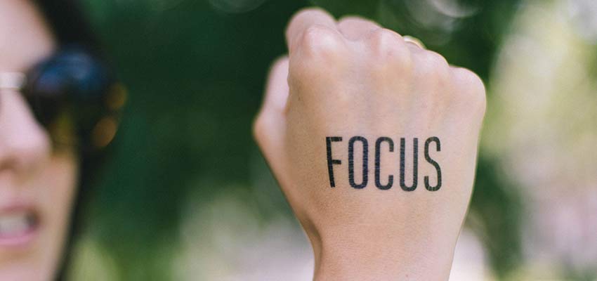 A woman with the word "Focus" written on the back of her hand.