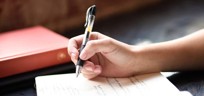 Person writing in a journal.