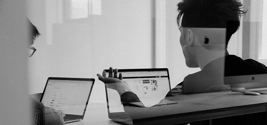 Two people sitting at a desk.