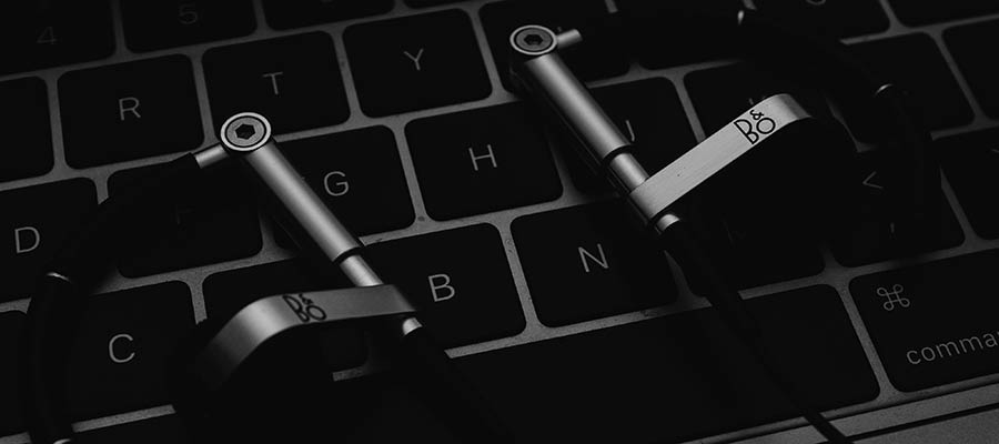 Headphones sitting on a keyboard.