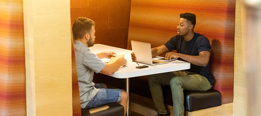 Two men in a restaurant booth.